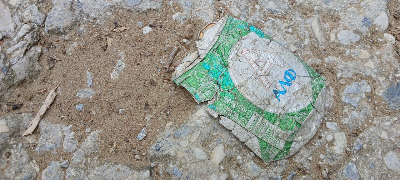 Eine plattgewalzte Bierdose aus Aluminium auf einem Feldweg